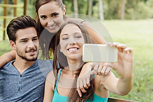 Cheerful teens at the park taking selfies