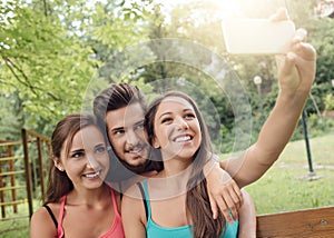 Cheerful teens at the park taking selfies
