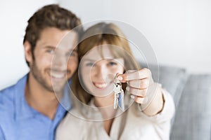 Cheerful thirty year old couple showing a keys of their new apartment photo