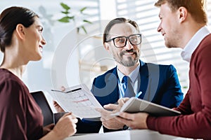 Cheerful three colleagues creating business plan