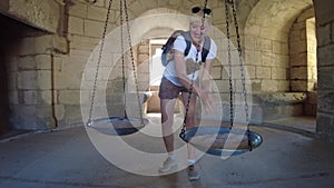 Cheerful tourist enjoying a swing at Aigues-Mortes castle
