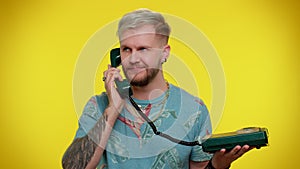 Cheerful tourist man secretary talking on wired vintage telephone of 80s, says hey you call me back