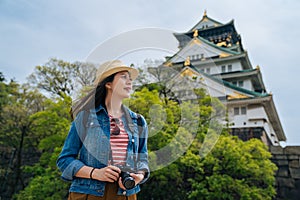 Cheerful tourist photographer hobby love traveling with slr camera sightseeing the city in japan. young attractive traveler