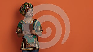 Cheerful traditional african woman using digital pad, copy space