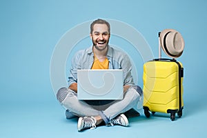 Cheerful traveler tourist man in summer casual clothes isolated on blue background. Passenger traveling abroad on