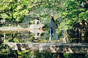 Cheerful traveler walking on stone bridge photo