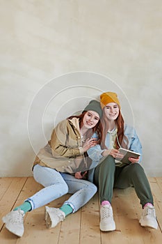Cheerful Twin Sisters Sitting On Floor