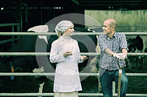 Cheerful veterinarian chatting with farmer