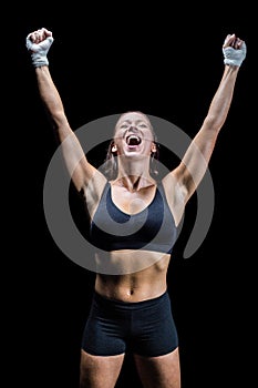 Cheerful winning athlete against black background