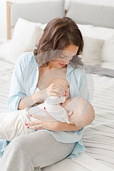 Cheerful woman with baby breast feeding