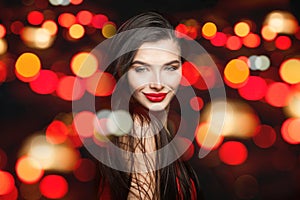 Cheerful woman brunette in black carnival masklong hair and red lips makeup on black background with abstract bokeh sparkle