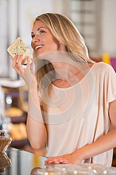 Cheerful woman buying cheese