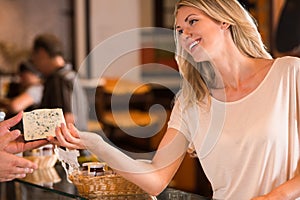 Cheerful woman buying cheese