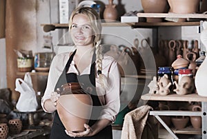 Cheerful woman carrying ceramic vessels