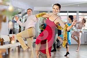 Cheerful woman dancing lindy hop with man at corporate Christmas party