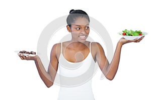 Cheerful woman deciding to eat healthily or not