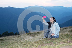 Cheerful woman doing selfie in the mountains