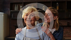 Cheerful woman embracing her elderly mother