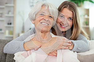 cheerful woman embracing senior mother