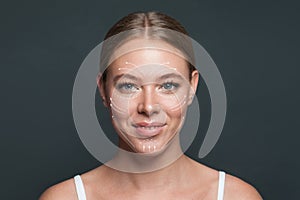 Cheerful woman. Face lift anti-aging lines on young female face. Graphic lines showing facial lifting effect on skin.