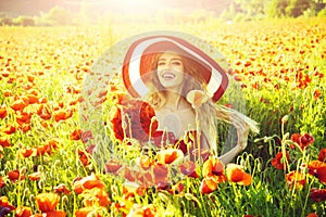 Cheerful woman on a flower field. girl in field of poppy seed in retro hat
