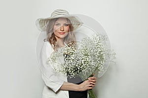 Cheerful woman with flowers on white background