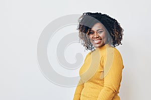 Cheerful woman with frizzy hairstyle dancing against white background