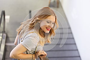 Cheerful woman going down the stairway and smiling