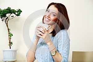 Cheerful woman holding cup with coffee