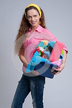 Cheerful woman holding different cleaning stuff