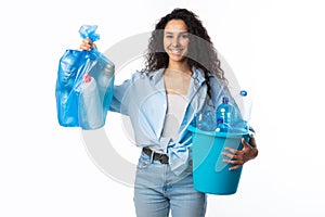 Cheerful Woman Holding Plastic Garbage Bag And Bucket, White Background
