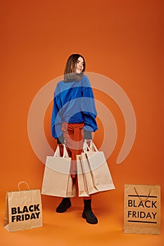 cheerful woman holding shopping bags and
