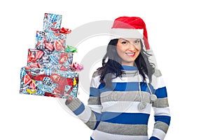 Cheerful woman holding stack of Christmas gifts