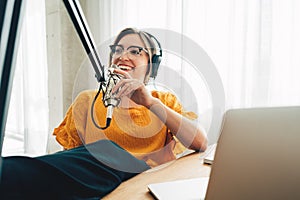 Cheerful woman host streaming his podcast using voice microphone