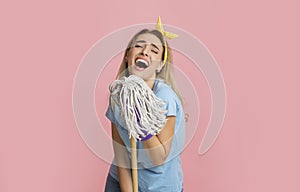 Cheerful woman imagines that she sings in mop