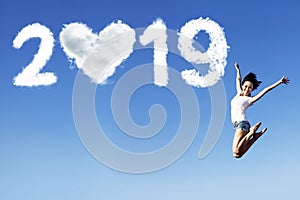 Cheerful woman jumps with number 2019