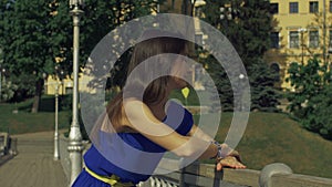 Cheerful woman leaning on the bannister of bridge