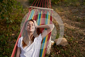 cheerful woman lies in a hammock in nature sun rest