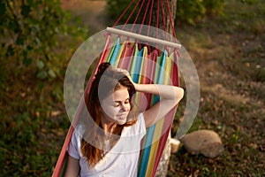 cheerful woman lies in a hammock in nature sun rest