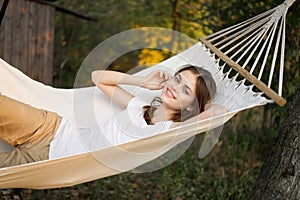 cheerful woman lies in a hammock rest nature fresh air