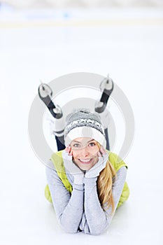 Cheerful woman lying on a skating rink