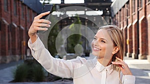 Cheerful woman making selfie photos having fun video chat using smartphone.