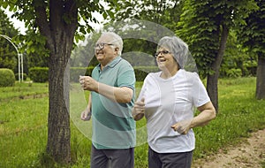 Cheerful woman and man with gray hair in the park.