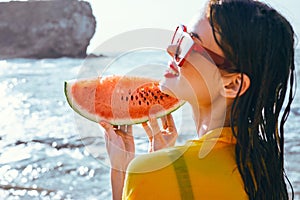 cheerful woman near the ocean with watermelon posing