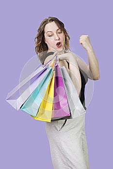 Cheerful woman with packages rejoices at successful purchases at sale