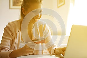 Cheerful woman paying bills.