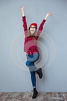 Cheerful woman posing with raised hands up