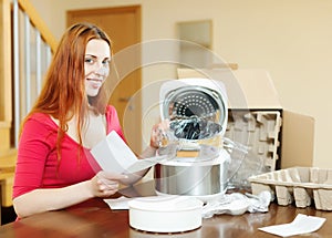 Cheerful woman reading guarantee for new slo-cooker
