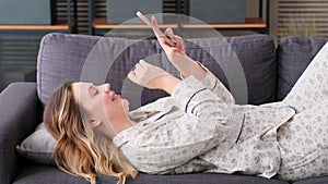 Cheerful Woman Relaxing On Sofa With Phone At Home