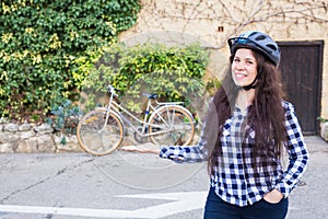 Cheerful woman represnt a bycycle on the background alley